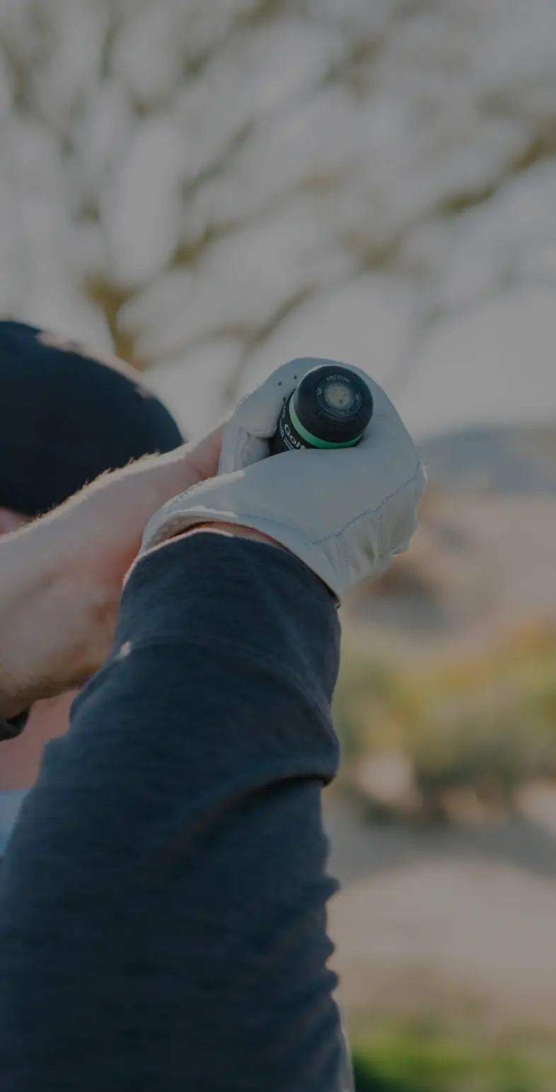 A golfer screwing an Arccos Smart Sensor into the end of a club grip